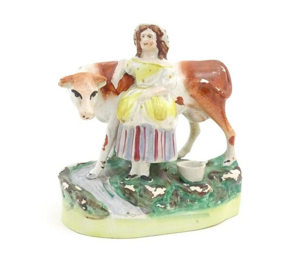 A Staffordshire pottery model of a cow with a milkmaid