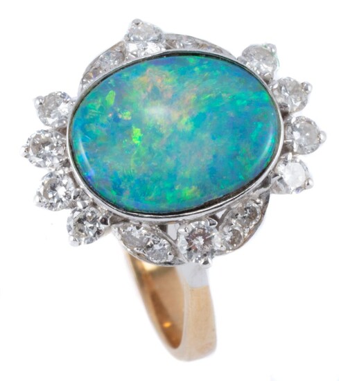 A TWO TONE 18CT GOLD OPAL AND DIAMOND RING; centring an approx. 3.66ct (13.2 x 10.7mm) boulder opal with good colour range surrounde...