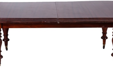 A Victorian-style mahogany dining table with turned legs on...
