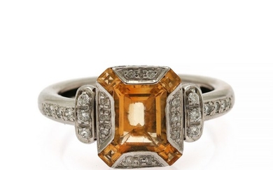 A citrine and diamond ring set with an emerald-cut citrine encircled by four square-cut citrines and numerous brilliant-cut diamonds, mounted in 14k white gold.