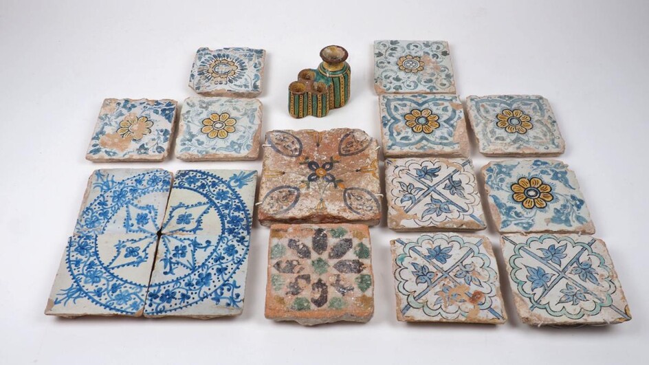 A group of tiles Southern European glazed tiles, 19th century, seven with flower motifs, four blue and white examples forming a circular pattern, and various other designs, 16 x 16cm square the largest; together with a green and yellow glazed...