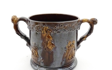 A large Staffordshire treacle glazed frog loving cup decorat...