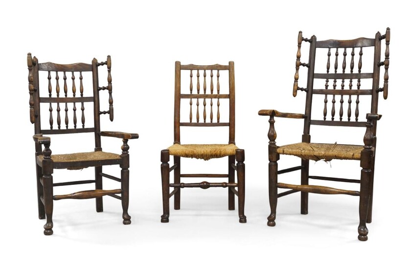 A near pair of oak wing back armchairs, 18th century, with turned spindle back rests and rush seats, together with a matching single chair (3)