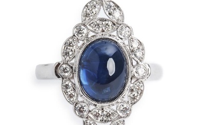 A sapphire and diamond ring set with a cabochon sapphire weighing app. 3.27 ct. encircled by numerous brilliant-cut diamonds weighing a total of app. 0.38 ct., mounted in 18k white gold. Size 53.