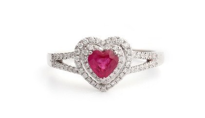 An 18ct white gold (stamped 750) ring set with a heart brilliant cut ruby surrounded by diamonds and diamond set shoulders, (O).
