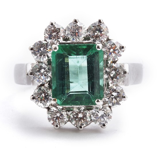 An emerald and diamond ring set with an emerald weighing app. 2.26 ct. encircled by numerous diamonds, mounted in 18k white gold. Size 55.
