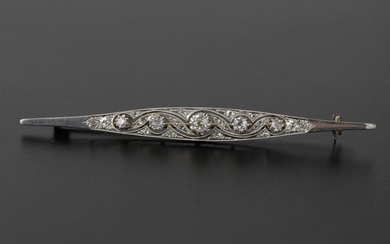 Brooch-barrette in platinum 850 thousandths and 18k yellow gold, with undulating openwork decoration enhanced with five antique cut diamonds, the bottom set with eighteen small rose-cut diamonds and two antique cut diamonds at each end.