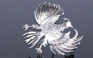 Broche en or gris figurant un aigle aux ailes déployées, son plumage finement dessiné.