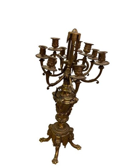 CANDELABRE en bronze doré et ciselé à neuf bras de lumières à décor de croisillons, guilralndes de lauriers, feuilles d'acanthes, masacrons, godrons et reposant sur des pieds griffres