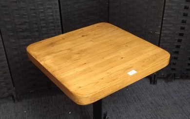 Charlotte Perriand: Une table carrée plateau en pin, piètement en métal laqué noir, modèle réalisé...