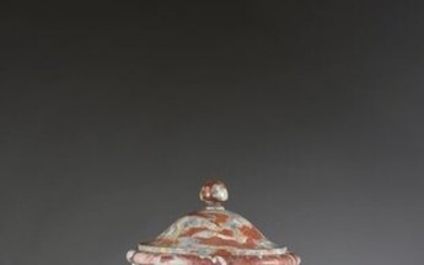 Covered vase in red Languedoc marble, baluster-shaped, the body decorated with large gadroons resting on a pedestal. (Formerly outside)