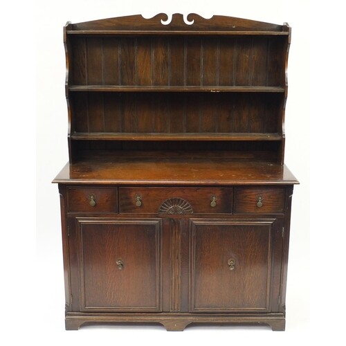 Oak dresser with open plate rack above three drawers and a p...