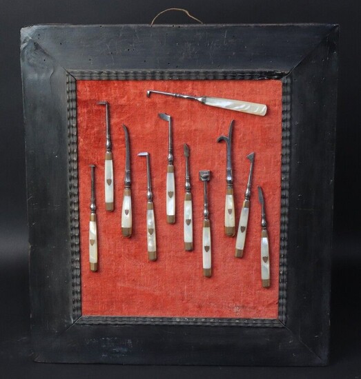Suite of ten steel surgical instruments with faceted joints mounted on mother-of-pearl handles. Gold ferrules and escutcheon. Early 19th century. An additional instrument with mother-of-pearl handle is attached.