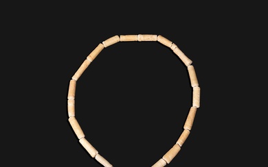 Un ancien collier constitué de tubes d’albâtre avec un terminal en forme de tête d’animal....