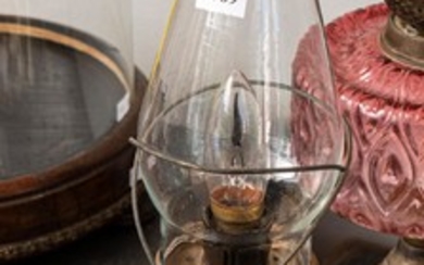 A RUBY GLASS KEROSENE LAMP WITH SHADE AND A VICTORIAN CLEAR GLASS TABLE LAMP WITH GLASS CHIMNEY (A/F WITH REPAIRS TO GLASS AND FAULTS)