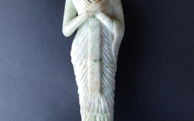 A Chinese celadon jade figure after the antique, depicting...