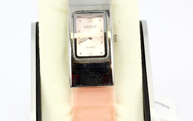 A Gucci quartz wristwatch on a translucent plastic strap.