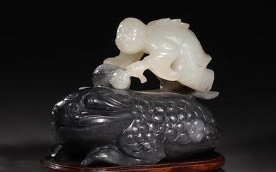 A HETIAN JADE CARVING OF LIU HAI PLAYING WITH A GOLDEN TOAD