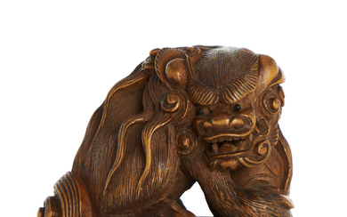 A JAPANESE WOOD NETSUKE OF A CHINESE MALE LION OR SHISHI, SIGNED ISSUI.