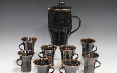 A Jeremy Leach Lowerdown pottery coffee pot and eight mugs, 1970s, each covered in a tenmoku glaze