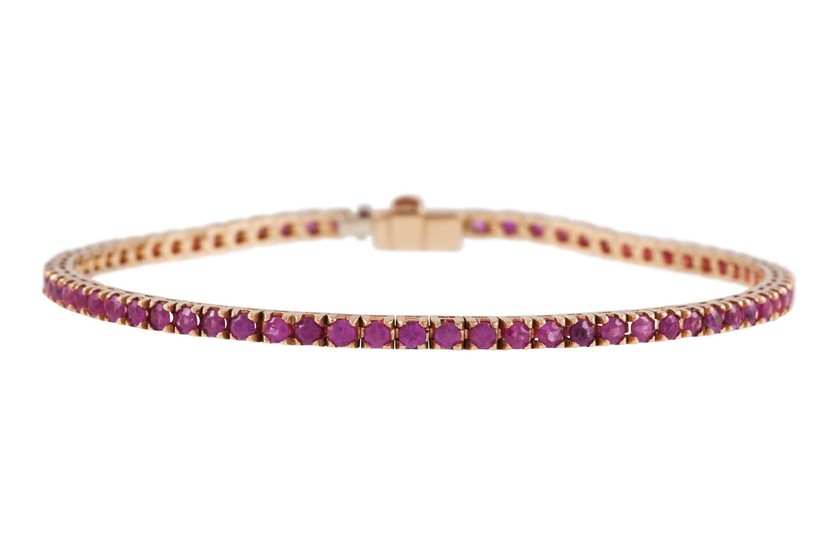 A RUBY SET LINE BRACELET, the rubies set in yellow gold. Est...