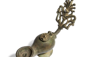 A Roman-style bronze oil lamp with elaborate open work handle of a palmette with dolphins, the lid cast with the head of Silenus, 18cm long and 14.8cm high Provenance: From the collection of the Late George Csonka (1916-2000)