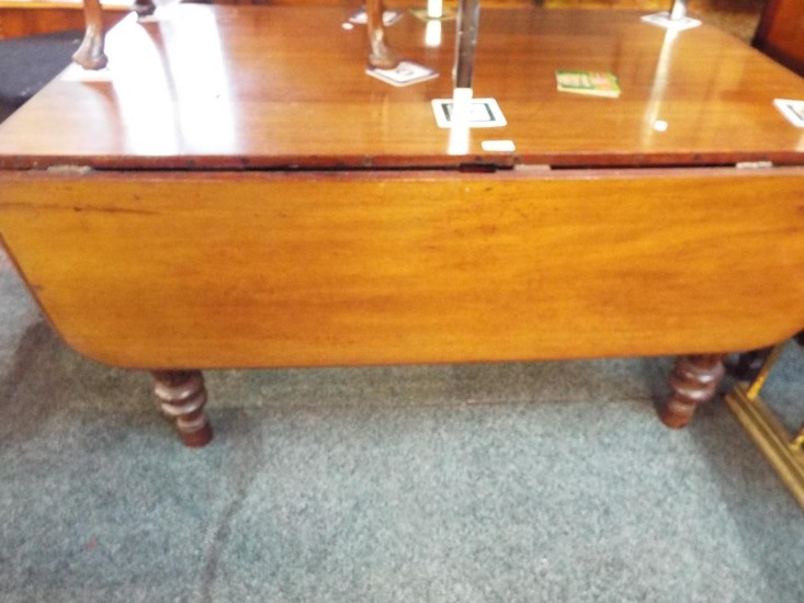 A Victorian mahogany drop leaf table having fluted and turne...
