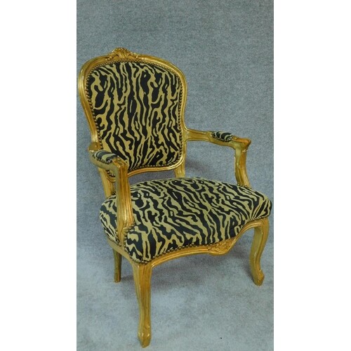 A gilt framed French style fauteuil in leopard print upholst...