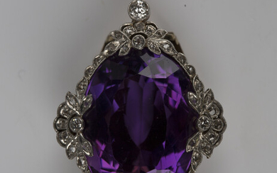 A gold, platinum, amethyst and diamond clip, mounted with the large oval cut amethyst within a diamo