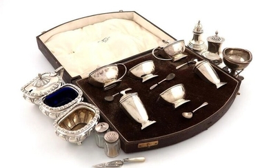 A mixed lot of silver items, comprising: a six piece Art Deco silver condiment set, by Walker and Hall, Birmingham 1931, in a fitted case, with spoons, plus a four-piece condiment set, a pepper pot, a tennis trophy, two silver and glass pepper pots...
