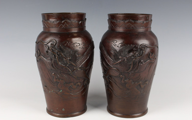A pair of Japanese bronze vases, Meiji/Taisho period, of shouldered tapering form, cast in relief wi