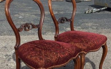 A pair of Victorian rosewood balloon back chairs with foliate...