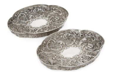 A pair of Victorian silver quatrefoil dishes, London, c.1891, Wakely & Wheeler, repousse decorated with exotic birds and foliate scroll motifs surrounding vacant scroll-bordered cartouches, 16.1 x 21cm, total weight approx. 13.7oz (2)