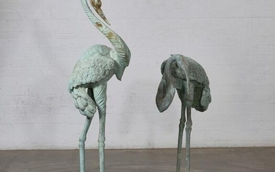 A pair of patinated metal models of cranes