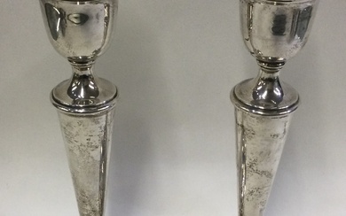 A pair of silver candlesticks of typical form.