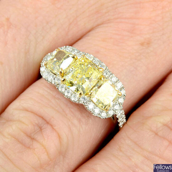 A platinum 'yellow' diamond and diamond three-stone cluster ring.