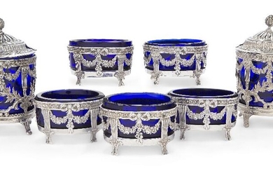 A set of five French Empire style salts, Paris, 1888-1902, marked MG for Martial Gauthier, the oval openwork bodies with with pierced ribbon tied floral swags on reeded supports, each with blue glass liner, 6.4cm wide; together with a pair of...