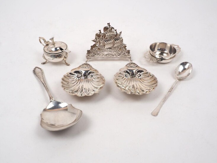 A small group of silver comprising: a Continental letter holder designed with two pierced ship panels, stamped 800; a tea strainer and stand, London, 1973, CJ Vander; two shell-shaped ashtrays Birmingham, 1974, William Adams, a silver mustard...