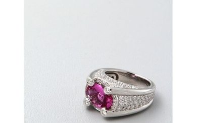 A white gold ring adorned with a large oval-shaped pink sapphire set with four diamond claws, the sides of the setting paved with diamonds.