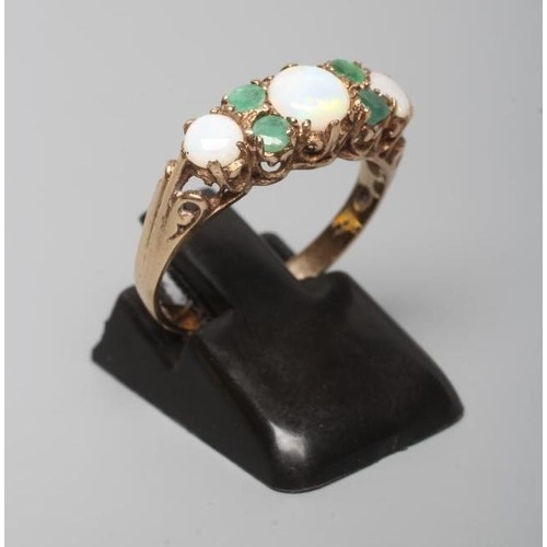 AN OPAL AND EMERALD RING, the three graduated cabochon opals...