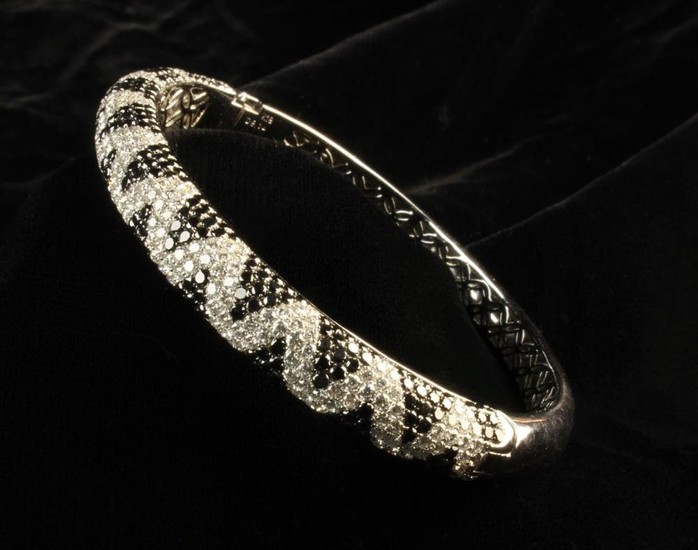 An 18 Carat White Gold & Diamond Bangle. Comprising of a tapering D-shaped cross-section pavé set in