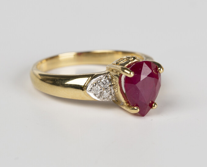An 18ct gold, ruby and diamond ring, claw set with the pear shaped ruby in a raised design between c