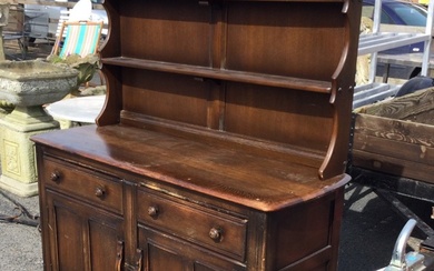 An Ercol elm dresser with moulded cornice and open shelves...