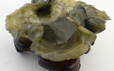 An Oriental carved spinach jade dish formed as a lotus