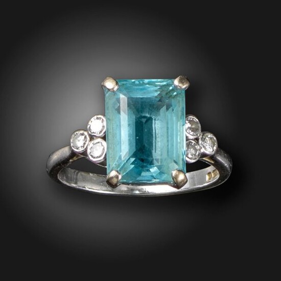 An aquamarine and diamond ring, the rectangular aquamarine is flanked...