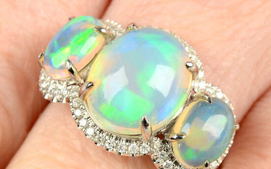 An opal three-stone and diamond ring.
