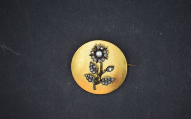 Broche ronde en or jaune 18k (750) ornée d'une fleur en argent sertie de diamants...