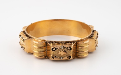 Important bracelet jonc en or jaune (750) à décor architecturé et filigrané de godrons et...