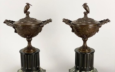Pair of decorative bronze lidded urns, of classical style with seated stork finials, raised on marble bases with fluted central columns. Circa 1870. Height 34cm.