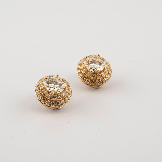 Pair of earrings in two-tone 750°/00 gold, each set with a large diamond (about 3.22 cts) in a double entourage of round brilliant diamonds. Diamond characteristics: in the centre NZVVS, for the HIVVS entourage. Clip system with the possibility of...